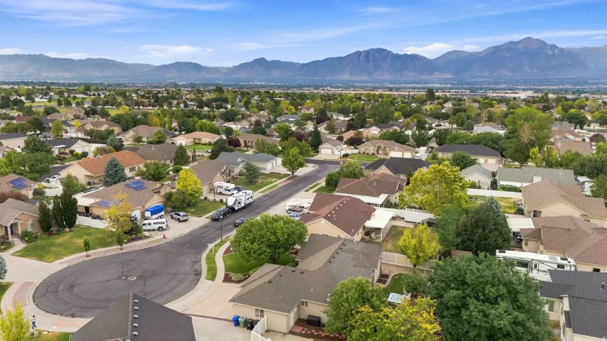 Mountain backdrop, residential neighborhood setting, cul-de-sac street, mature trees, single-story homes