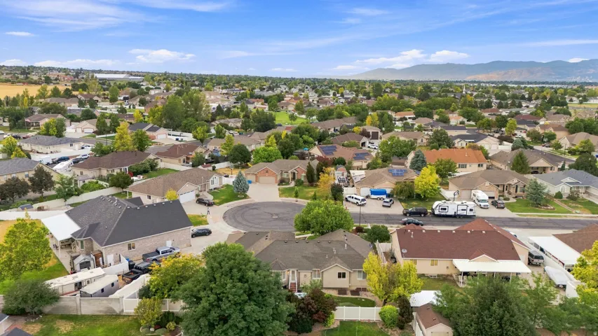 Residential neighborhood setting with mature trees and a distant mountain backdrop