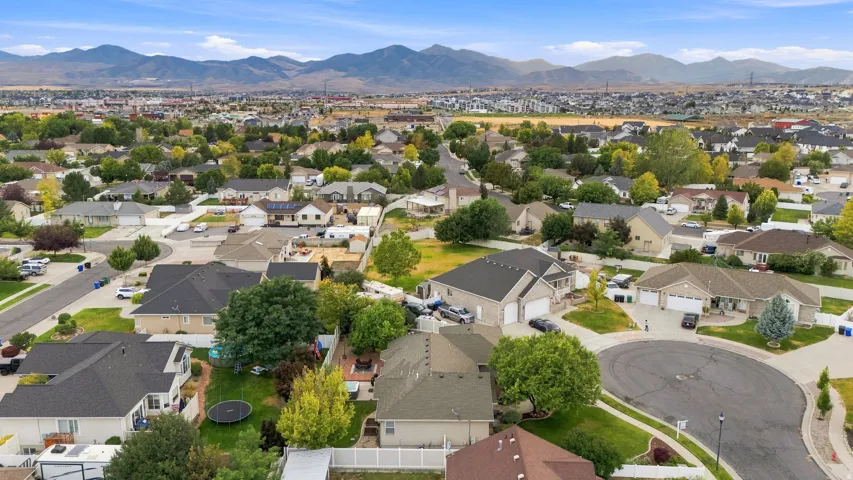 Residential neighborhood featuring varied rooflines, mature trees, and mountainous terrain