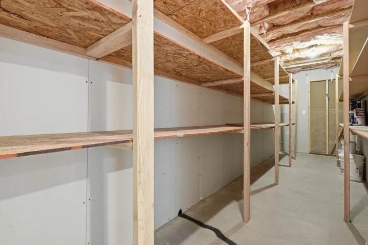 Built-in shelving units, concrete flooring, and exposed ceiling insulation