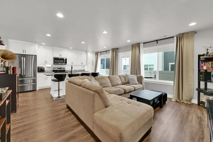 Open-concept living area featuring a sectional layout with  LVP wood-finish flooring throughout