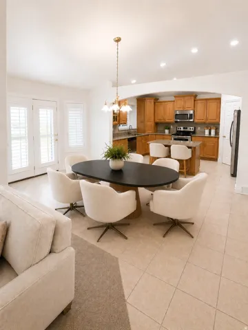 Recessed lighting, tile flooring, French doors with plantation shutters, an arched doorway, and wood cabinetry in the kitchen