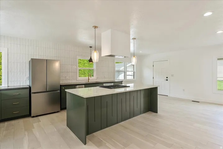 Modern kitchen featuring a large center island, quartz countertop, and pendant lighting