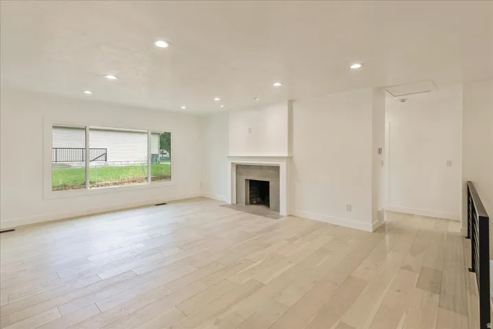 Spacious living area flooded with natural light through expansive sliding glass doors Windows overlooking the grounds