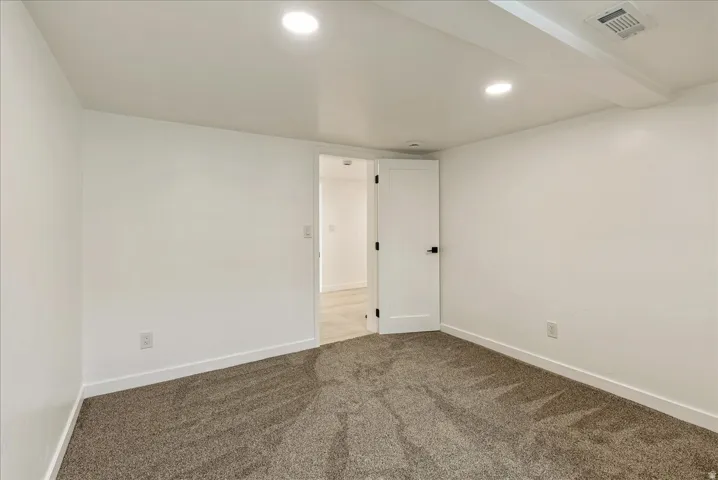 Bright secondary bedroom with recessed ceiling lighting, neutral wall finishes, and carpet flooring