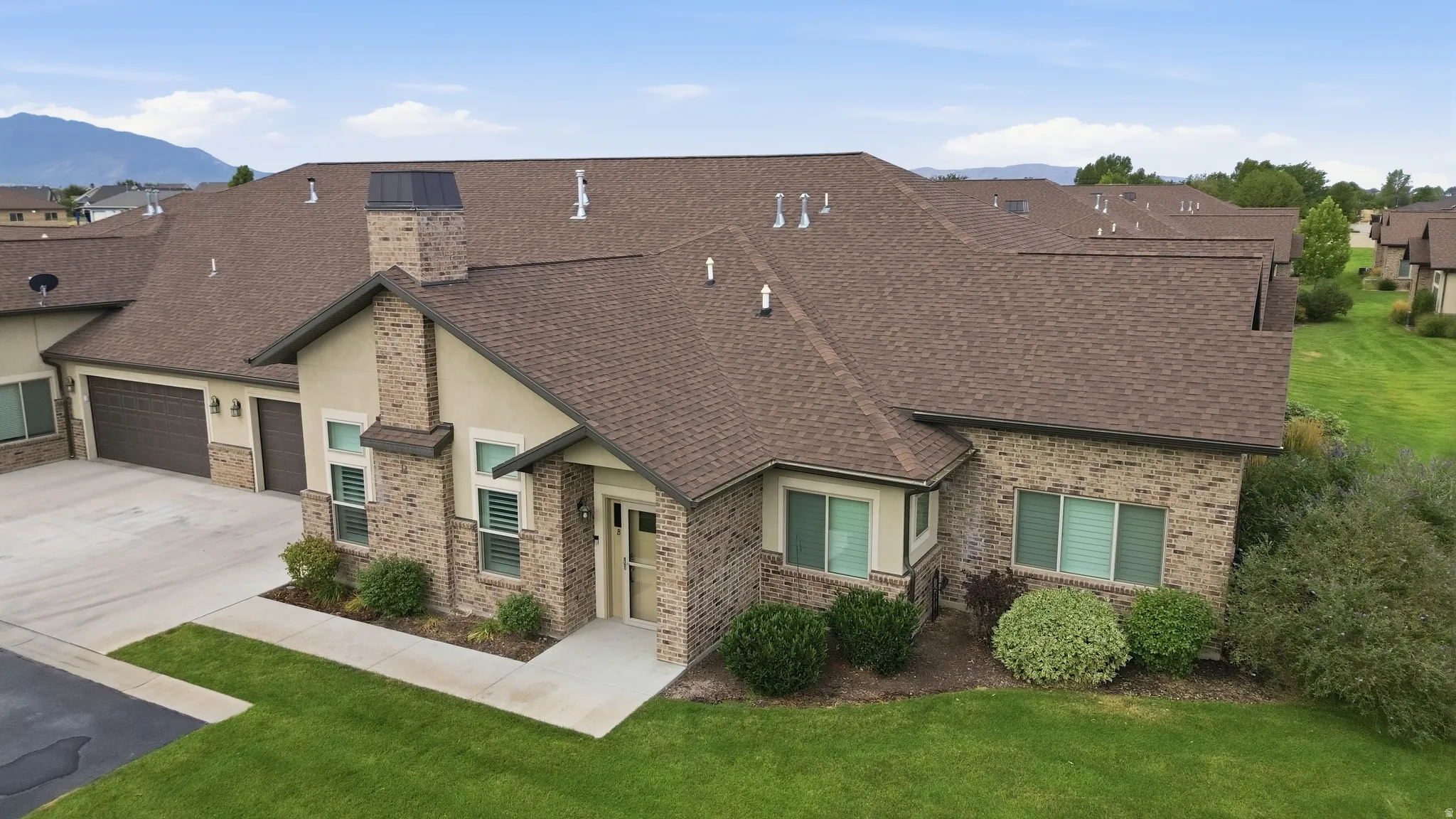 Stunning brick and stone exterior with architectural chimney details and multiple rooflines