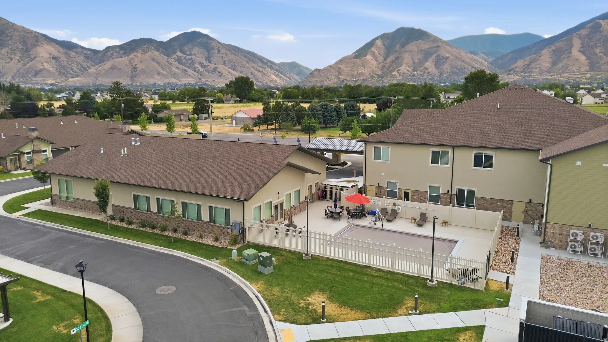 Expansive residential community featuring multiple single-story structures with earth-tone exterior finishes, pitched rooflines, and architectural variety
