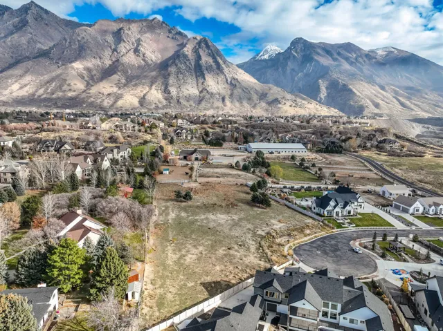 View of property centered with mountain background and nearby suburban area
