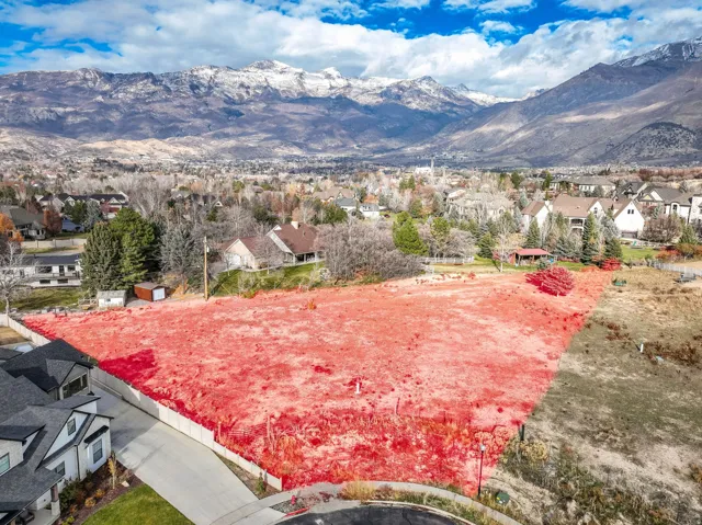 View of property highlighted with mountain backdrop featuring nearby suburban area