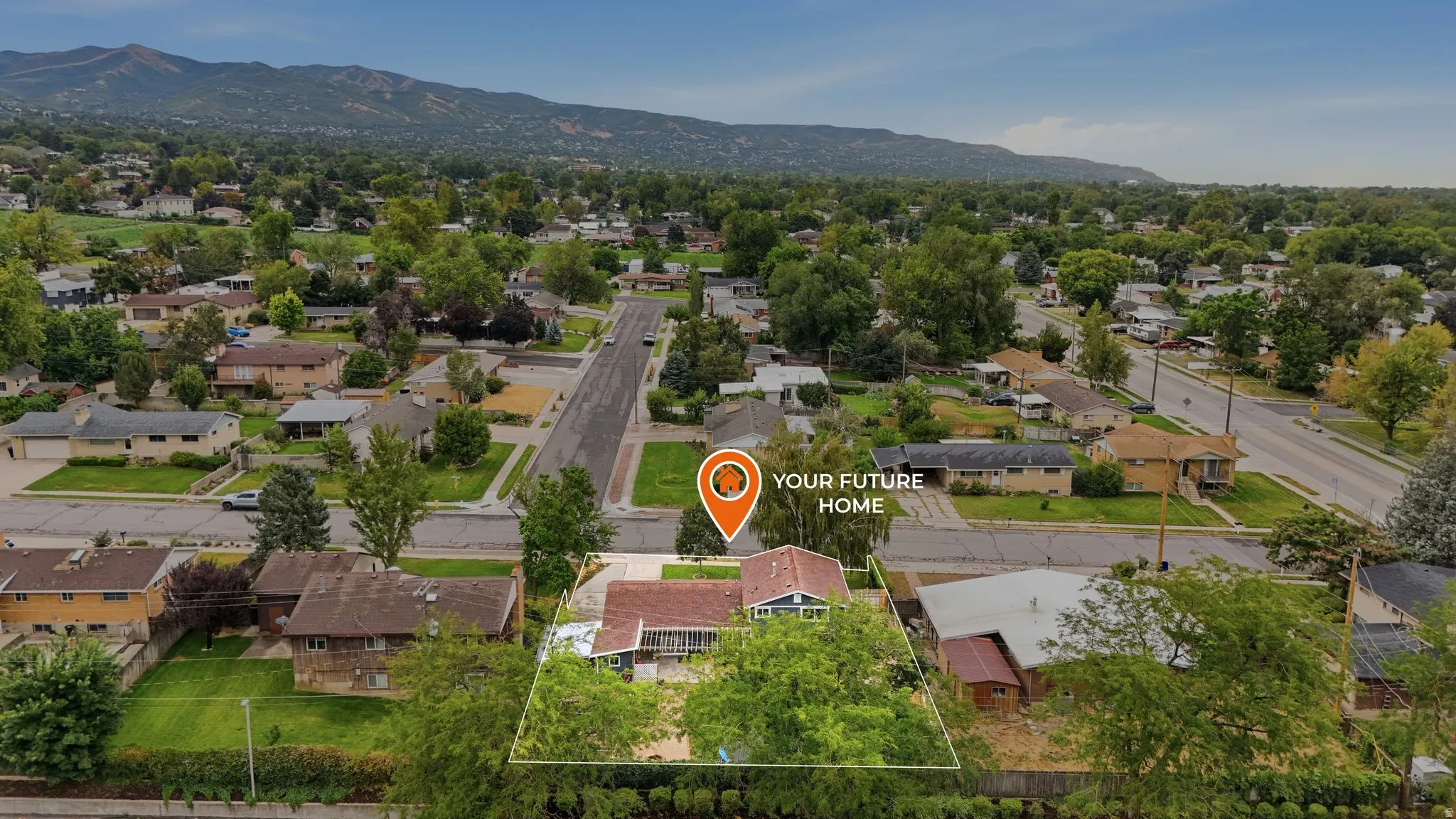Aerial view showcasing this residential property situated on an expansive lot with mature landscaping, multiple outbuildings, and direct street frontage