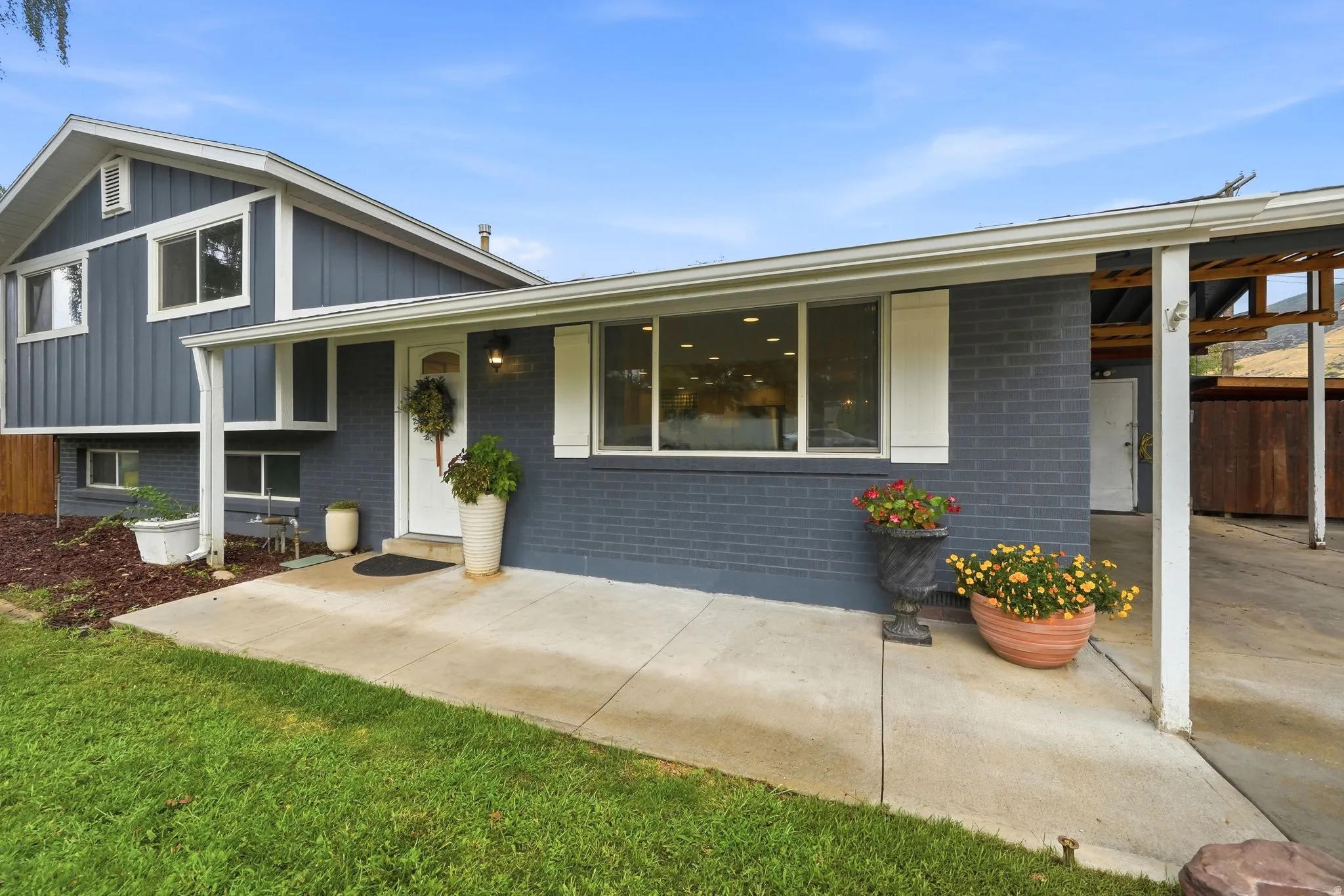 Split-level exterior featuring vertical siding and painted brick