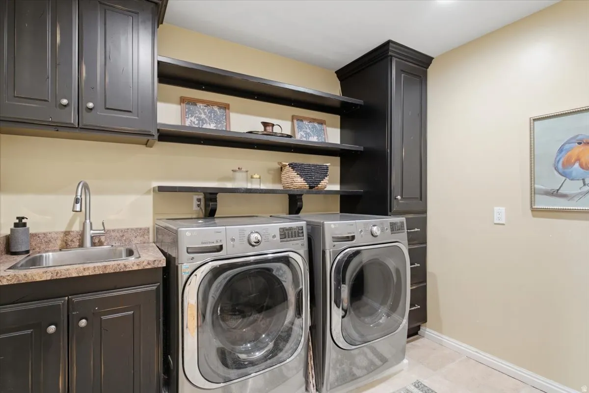 Built-in cabinetry in a dark finish, utility sink with a high-arc faucet, open shelving, and a tall storage cabinet