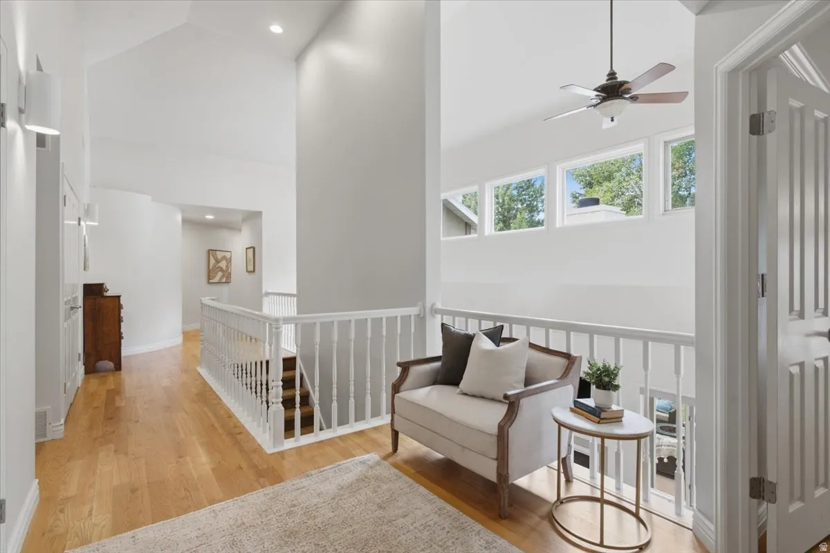 Hardwood flooring, vaulted ceilings, recessed lighting, and white balusters
