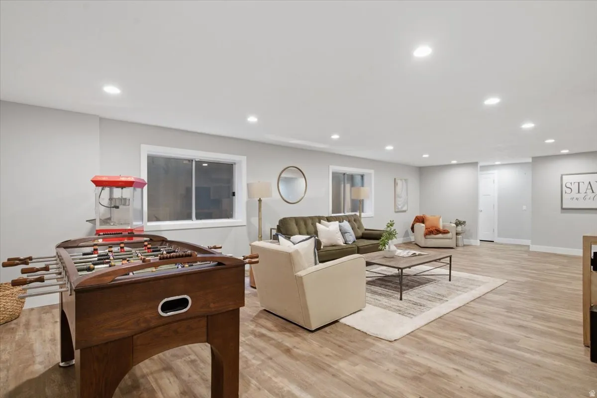 Recessed lighting, light wood-finish flooring, light gray wall paint, and white trim throughout