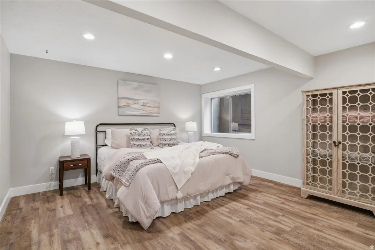 Recessed lighting, wood-finish flooring, and a large egress window