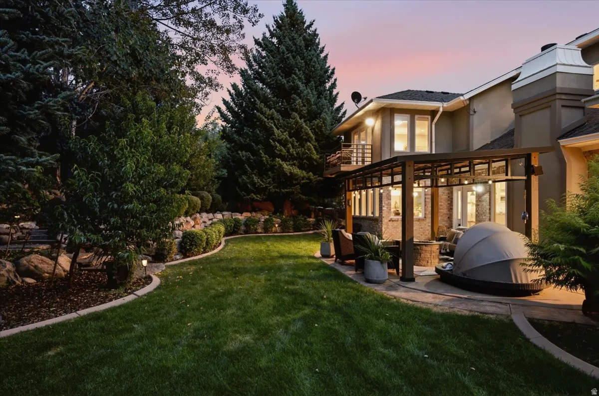 Expansive lawn with concrete edging, stone retaining wall, and mature landscaping