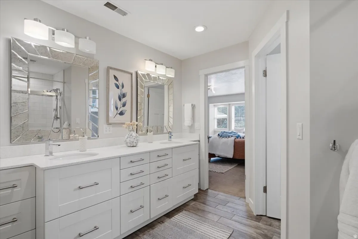 Dual vanity with white cabinetry, polished chrome fixtures, and white countertops