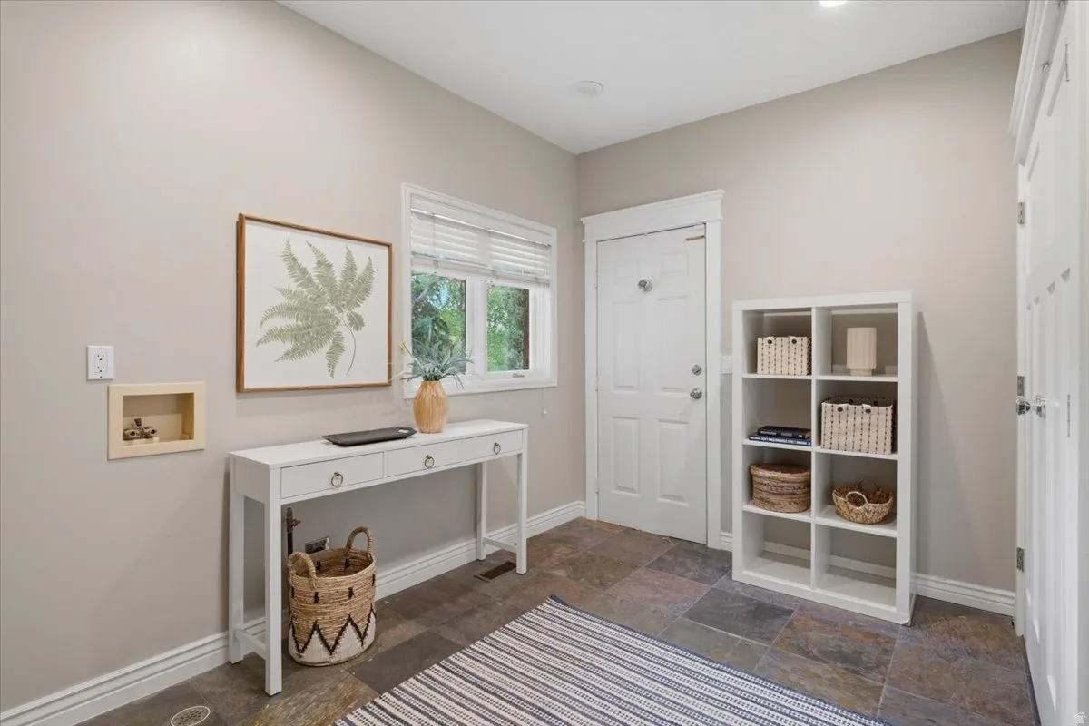 Slate tile flooring, white trim, recessed lighting, double-pane window, paneled entry door
