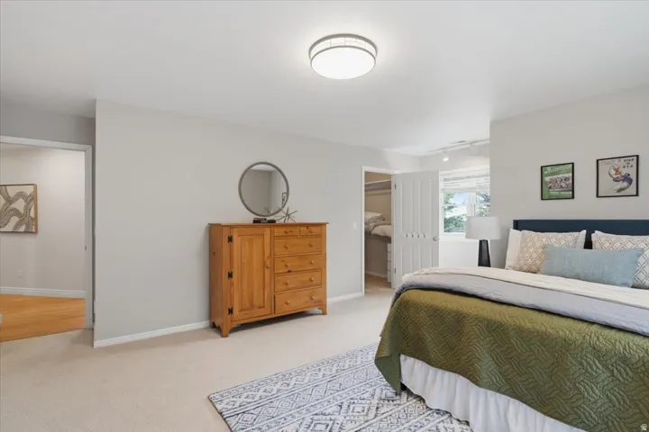 Carpeted flooring, light gray wall color, flush mount ceiling light, and a double-door closet with louvered doors
