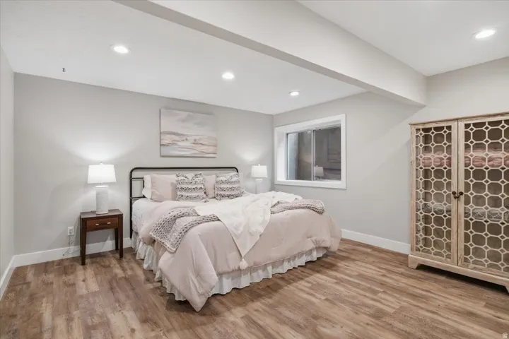 Recessed lighting, wood-finish flooring, and a large egress window