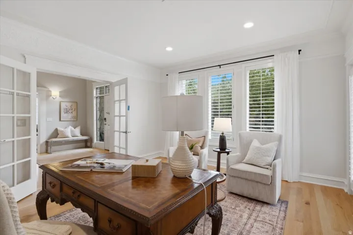 Hardwood flooring, recessed lighting, white window shutters, and French doors with glass panels