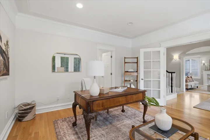 Hardwood flooring, crown molding, recessed lighting, French doors, and an arched doorway