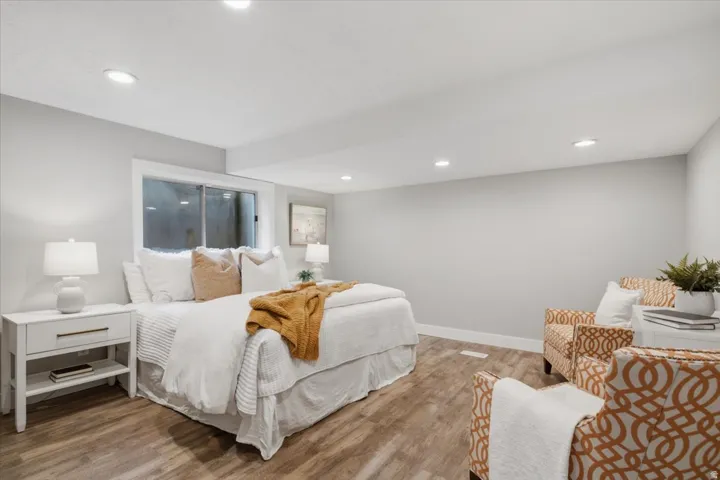 Recessed lighting, wood-finish flooring, white trim, and a window with a deep sill