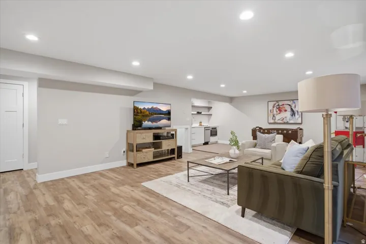 Recessed lighting, wood-finish flooring, white paneled door, built-in shelving, and light gray walls