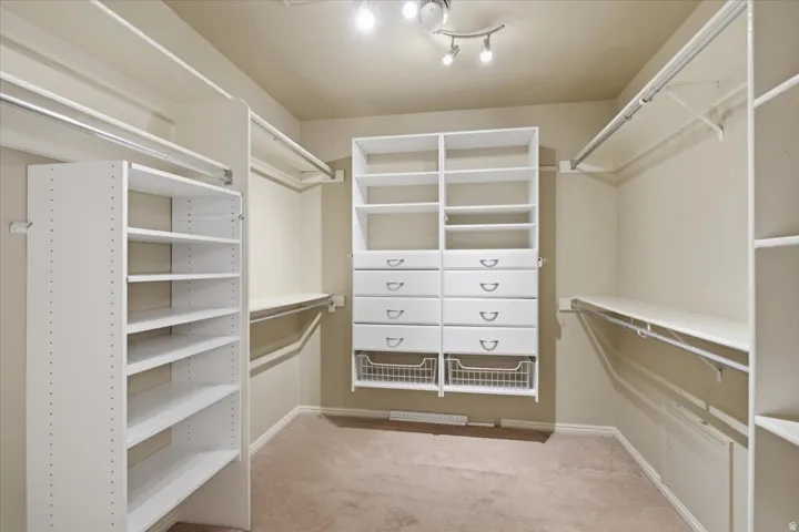 Built-in closet system featuring shelving, drawers, and hanging rods