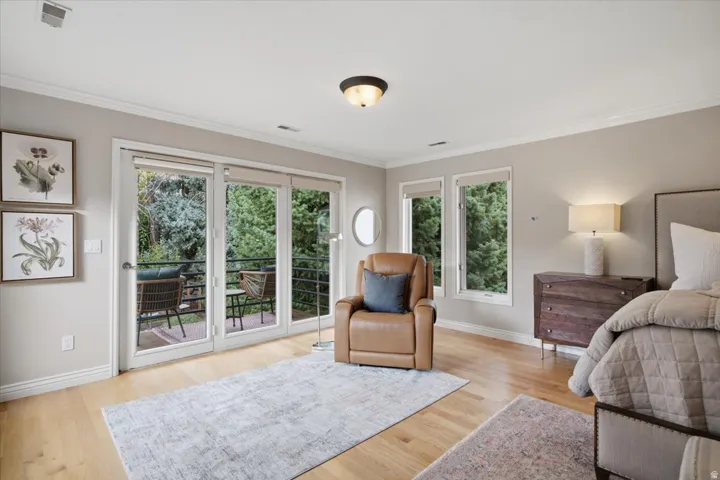 Hardwood flooring, crown molding, double French doors, large windows, and a recessed ceiling light fixture