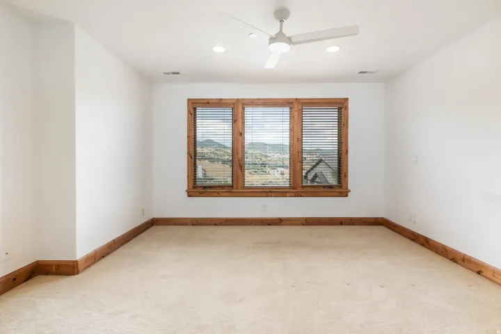 Triple window with wood trim, recessed lighting, ceiling fan, and light-toned carpeting