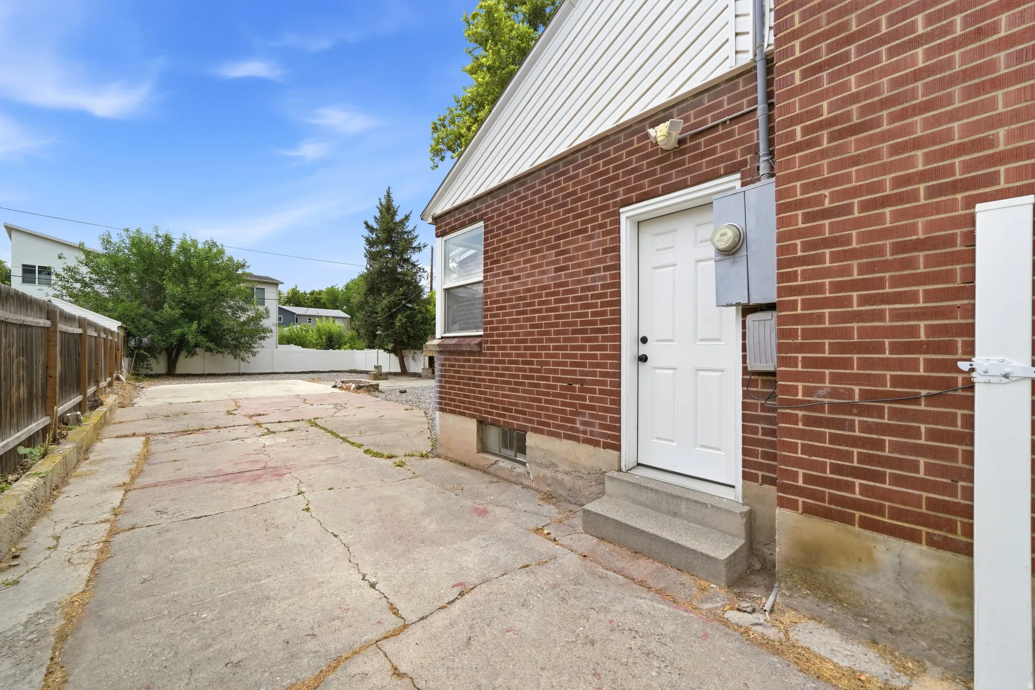 Brick exterior with side entrance featuring a white door and window