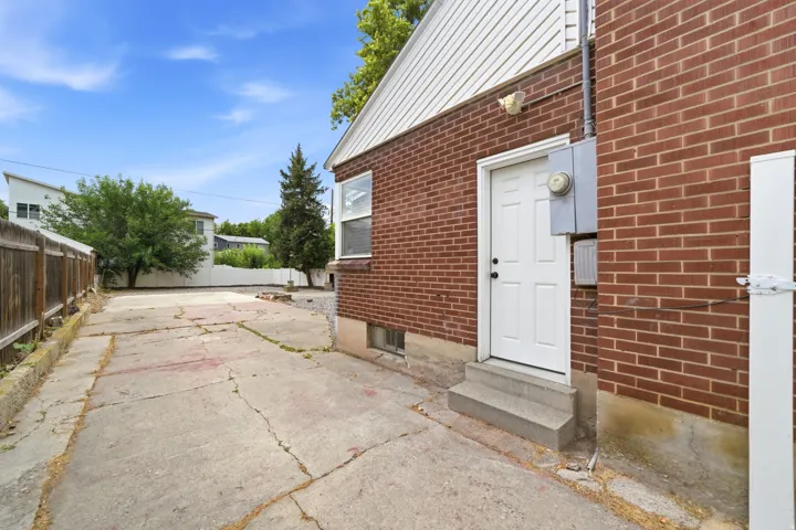 Brick exterior with side entrance featuring a white door and window