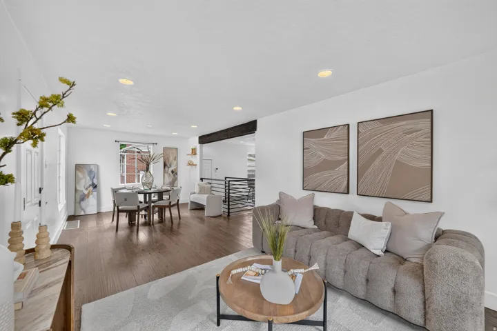 Open-concept living space featuring wood-finish flooring, recessed lighting, and a dining area with a window