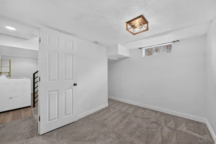 Spacious bedroom with neutral wall finishes, plush carpeting, and abundant natural light from recessed ceiling fixtures