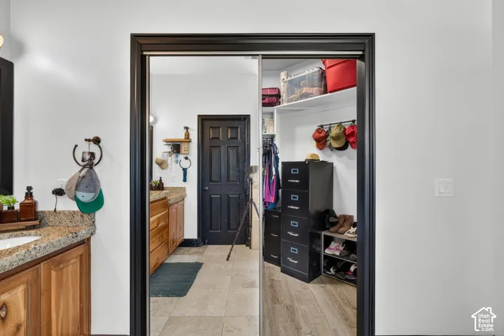 Spacious walk-in closet featuring built-in shelving with adjustable shelves, black storage drawers, and abundant storage capacity