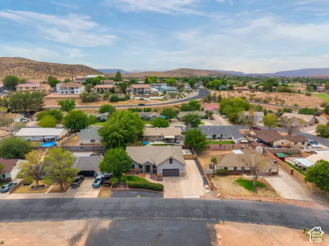 Suburban neighborhood setting with established landscaping, and distant hills