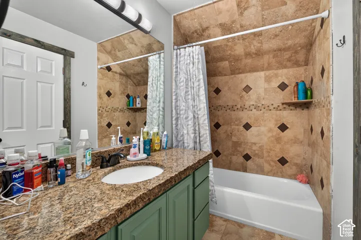 Bathroom vanity with a granite countertop, undermount sink, and green base cabinetry