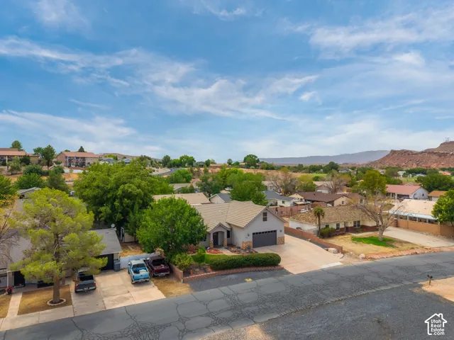 Single-story residence featuring a two-car garage, stone and stucco exterior, and a paved driveway