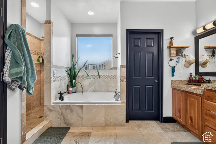 Built-in bathtub with black fixtures, tile surround, and privacy window