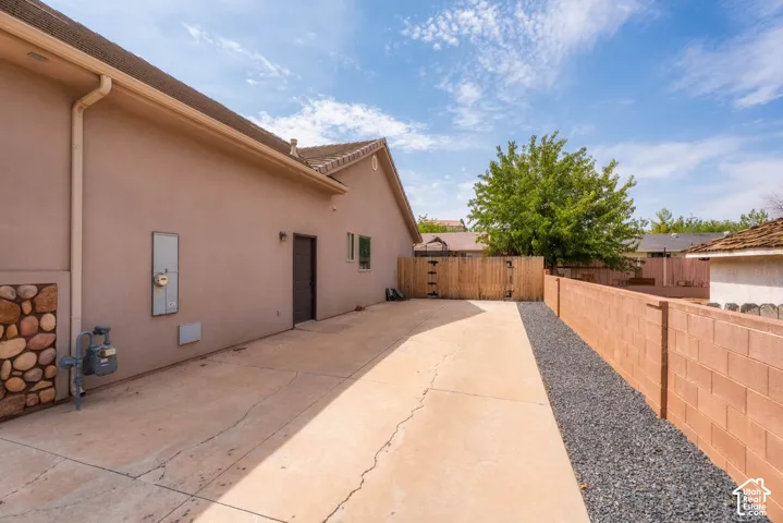 Expansive concrete patio with gravel border offering ample outdoor entertaining space