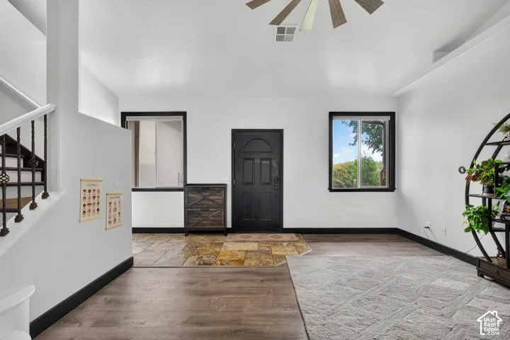 Spacious open-concept foyer with wood-finish flooring and polished concrete accents, offering abundant natural light through multiple windows