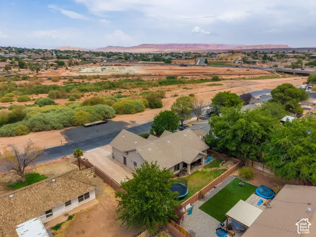 Scenic riverside property featuring a modern residence with metal roof, mature landscaping, and expansive grounds overlooking pastoral terrain