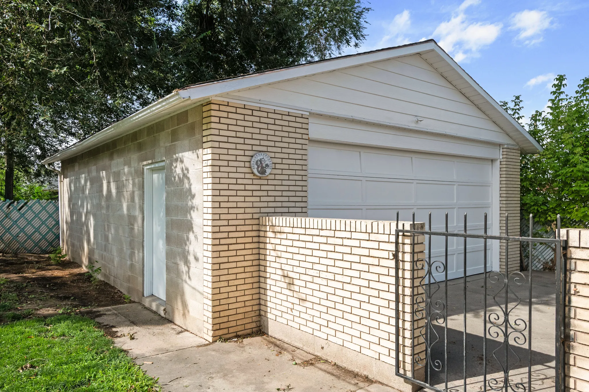 Brick and block exterior garage with a white overhead door and an exterior side door
