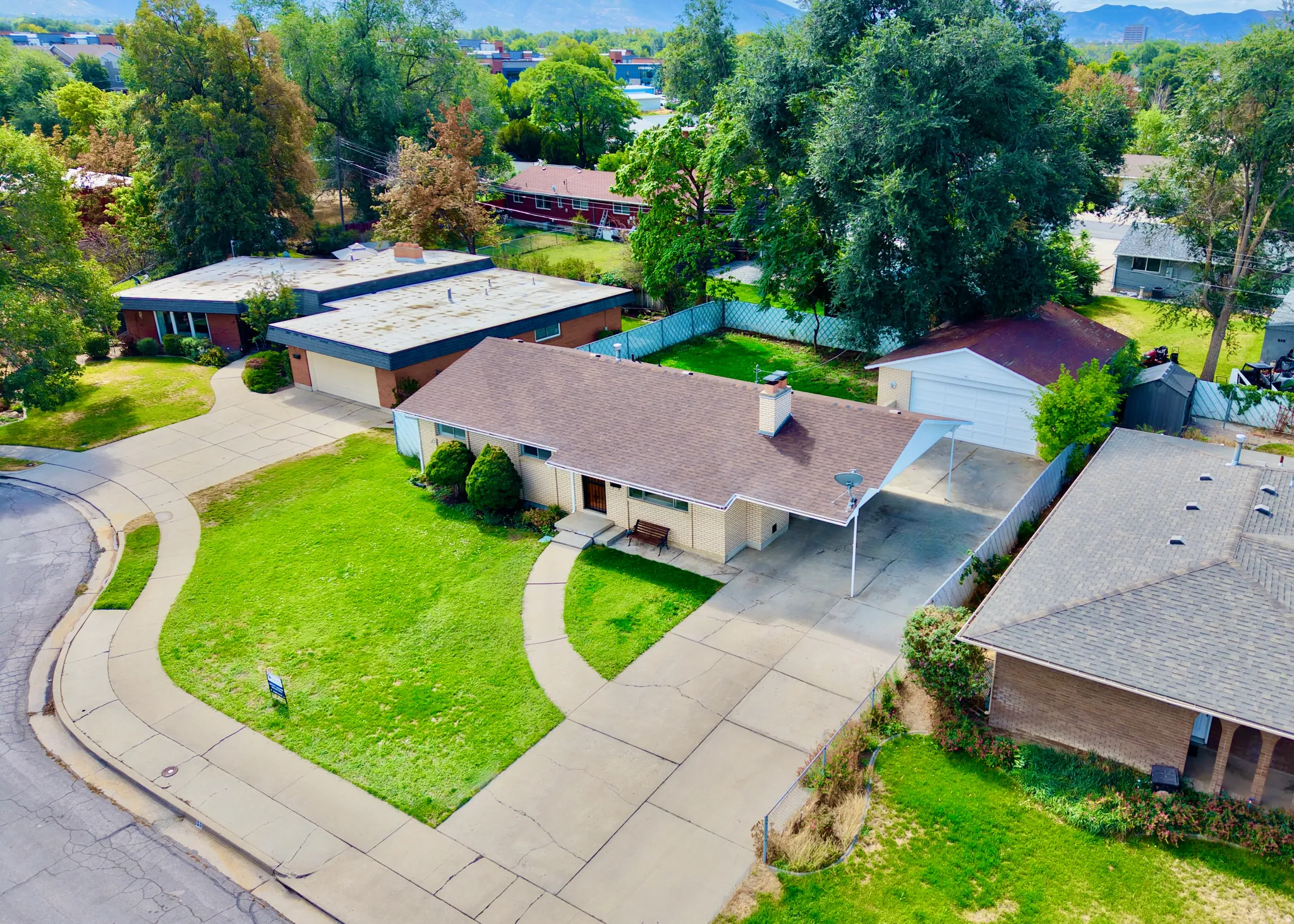 Single-story residence with a covered carport, attached garage, and a lush green lawn