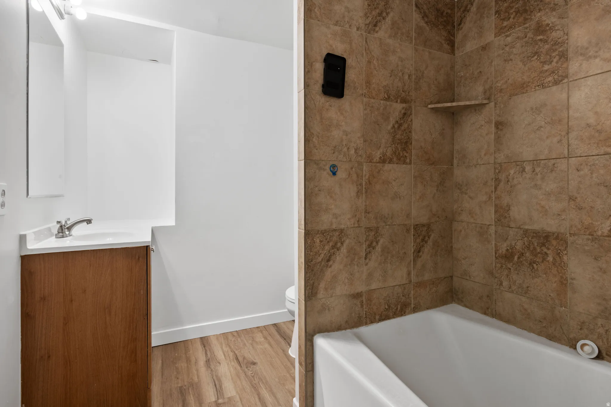 Wood-finish flooring with a white vanity and integrated sink