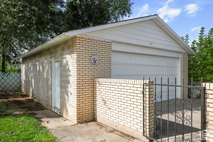 Brick and block exterior garage with a white overhead door and an exterior side door