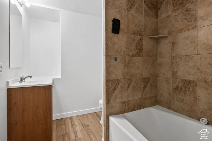 Wood-finish flooring with a white vanity and integrated sink