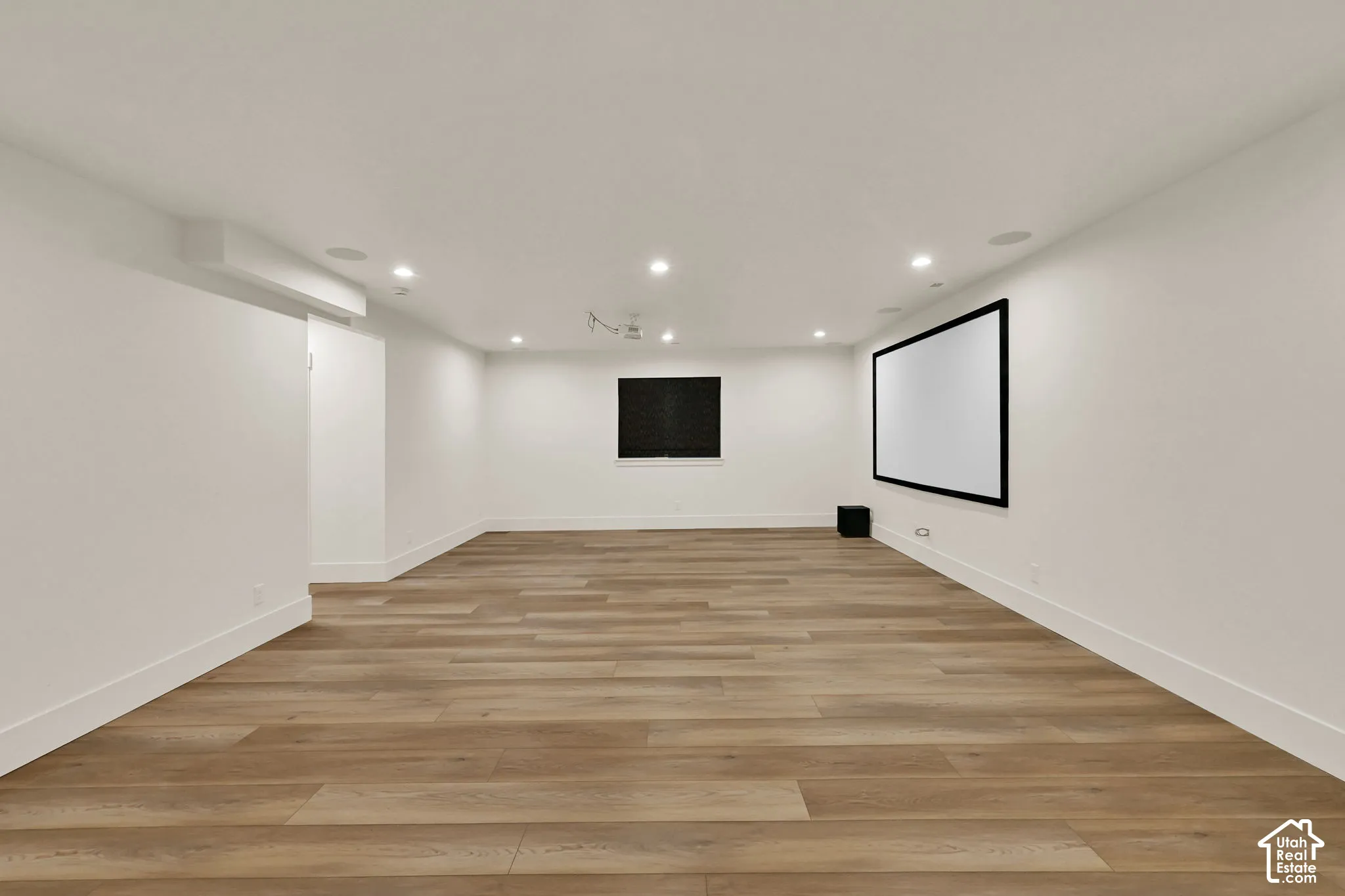 Recessed lighting, wood-finish flooring, integrated projection screen, ceiling-mounted projector, and ceiling-mounted speakers