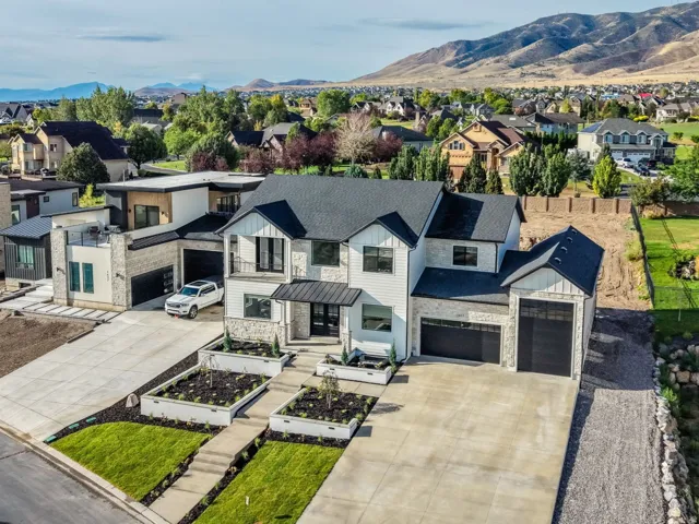 Modern two-story residence featuring a clean-lined facade with mixed exterior finishes, a spacious concrete driveway, and manicured front landscaping with newly sodded lawn